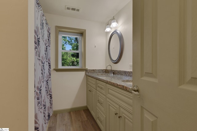 bathroom featuring double vanity, wood finished floors, baseboards, and curtained shower