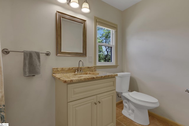 bathroom featuring toilet, baseboards, vanity, and tile patterned flooring