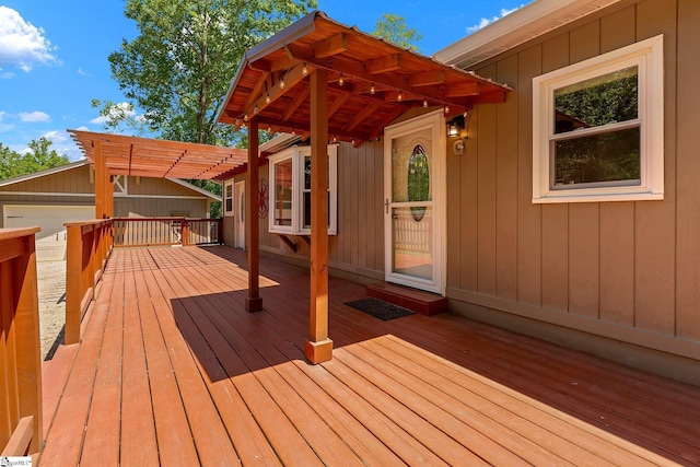 wooden deck featuring a pergola and an outdoor structure