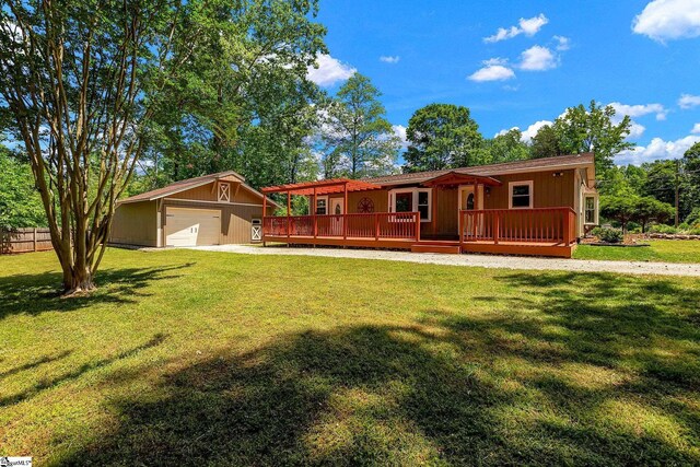 view of front facade with a wooden deck, an outdoor structure, and a detached garage