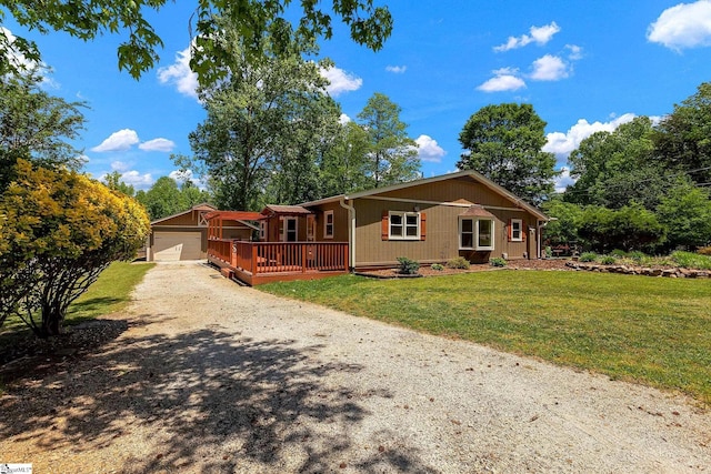 view of front of home with driveway, a front lawn, an attached garage, and a wooden deck