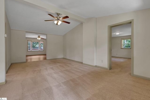 carpeted empty room with ceiling fan, plenty of natural light, and baseboards