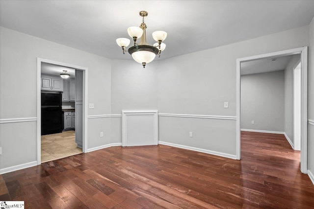 215 Rebecca St, Greenville, SC 29607 - unfurnished dining area featuring a chandelier, wood finished floors, and baseboards