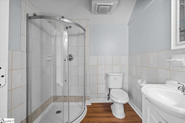 215 Rebecca St, Greenville, SC 29607 - full bathroom featuring a shower stall, tile walls, toilet, vanity, and wood finished floors