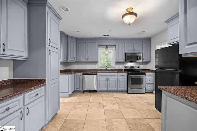 215 Rebecca St, Greenville, SC 29607 - kitchen with appliances with stainless steel finishes, a sink, gray cabinetry, dark stone counters, and recessed lighting