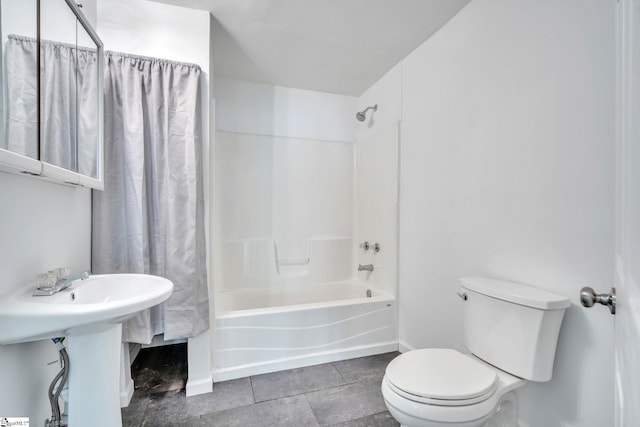 bathroom featuring toilet, shower / bath combo with shower curtain, baseboards, and tile patterned flooring