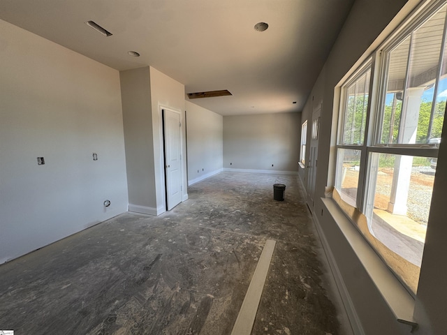 unfurnished room with baseboards