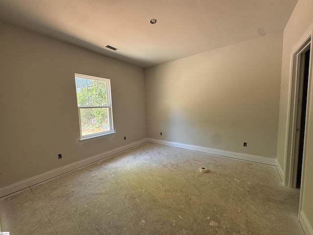 unfurnished room with baseboards and concrete floors
