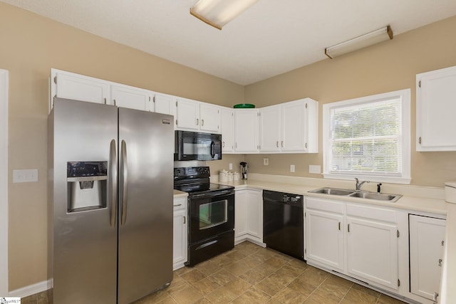 kitchen with black appliances, a sink, white cabinets, and light countertops