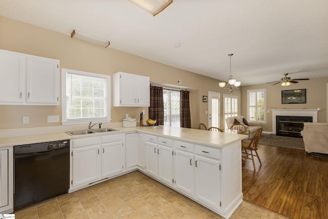 kitchen with black dishwasher, a sink, and light countertops