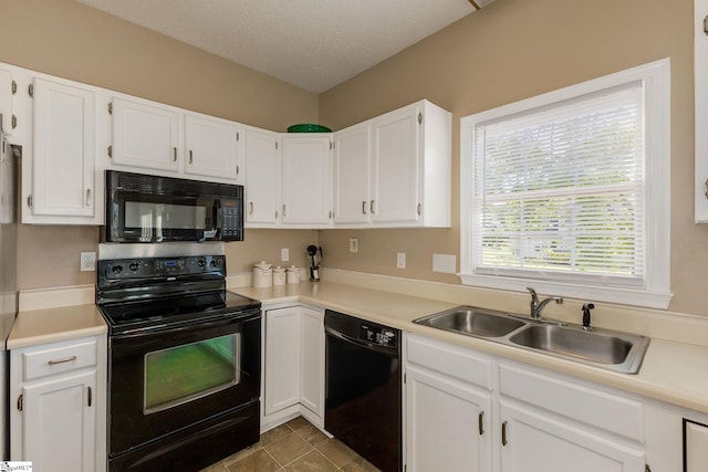 kitchen with black appliances, a sink, white cabinetry, light countertops, and a textured ceiling