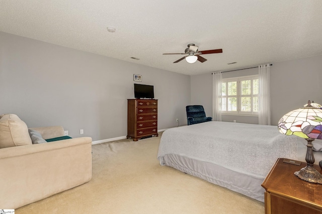 bedroom featuring light colored carpet, a ceiling fan, baseboards, and a textured ceiling