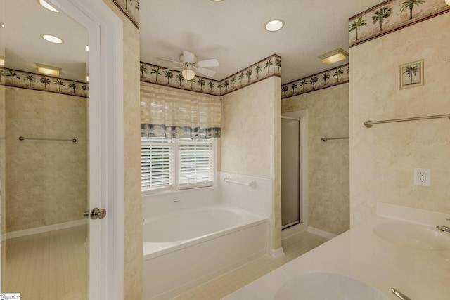 bathroom featuring a stall shower, a bath, a ceiling fan, double vanity, and tile patterned floors