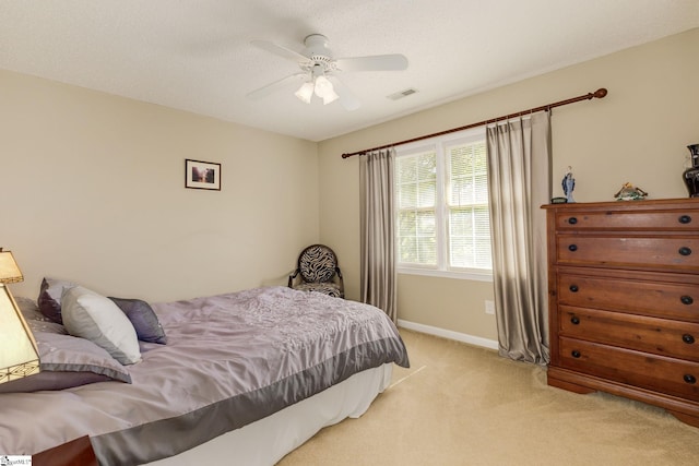bedroom featuring light colored carpet, baseboards, and a ceiling fan