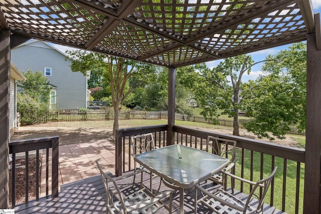 deck featuring a pergola, view of wooded area, and outdoor dining area