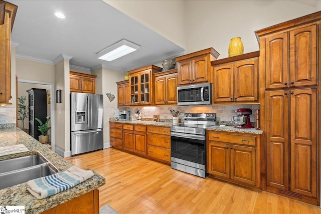 kitchen with stainless steel appliances, brown cabinetry, backsplash, ornamental molding, and recessed lighting