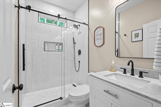 bathroom with toilet, a shower stall, and vanity