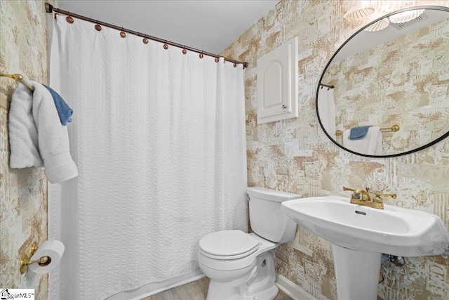 full bath featuring wallpapered walls, toilet, and a shower with shower curtain