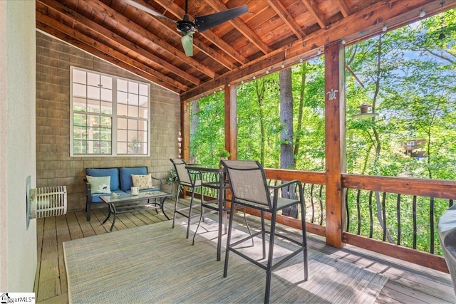 sunroom with vaulted ceiling, ceiling fan, and an outdoor living space