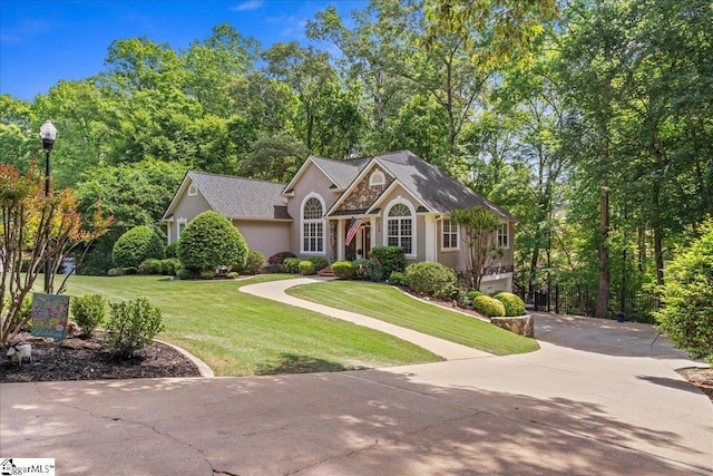 view of front of home featuring stucco siding, driveway, a front lawn, and an attached garage