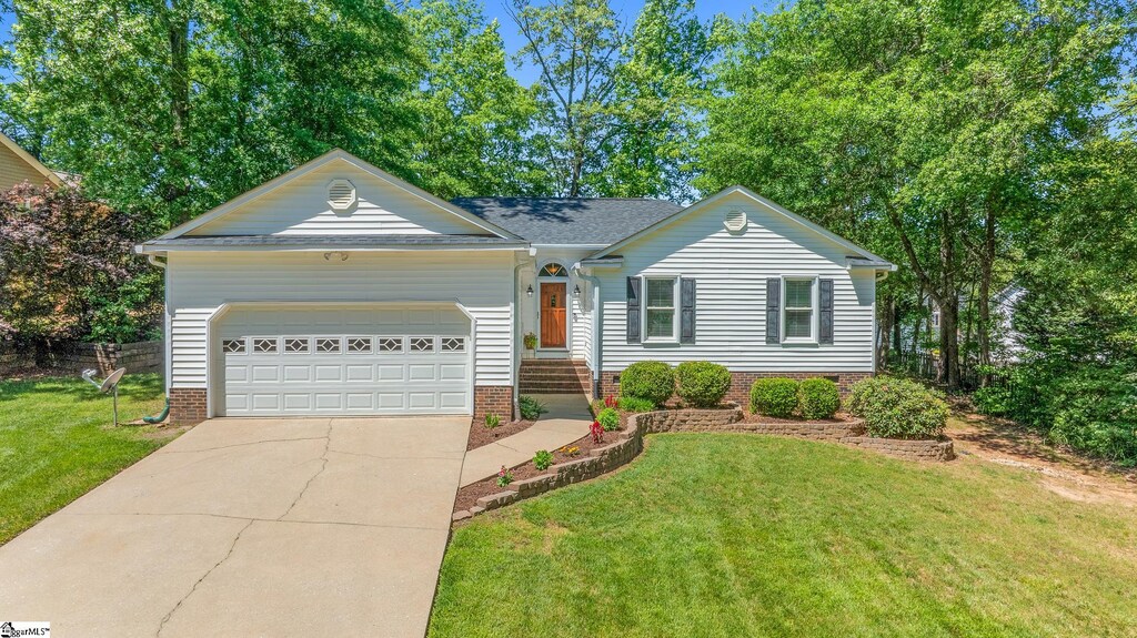 single story home featuring a garage, concrete driveway, a front yard, and roof with shingles