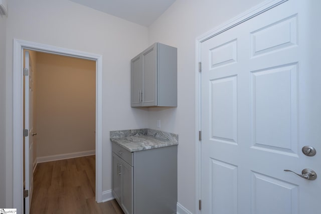 clothes washing area featuring dark wood-style floors and baseboards