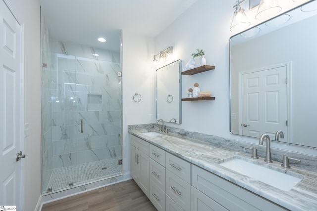 bathroom with a stall shower, double vanity, recessed lighting, and wood finished floors