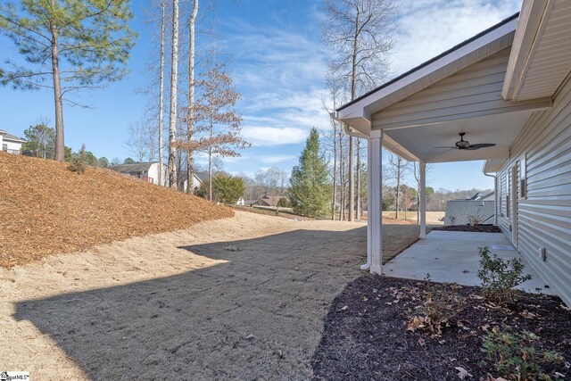 view of yard featuring ceiling fan and a patio area