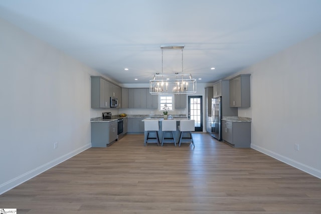 kitchen featuring gray cabinetry, stainless steel appliances, a chandelier, recessed lighting, and baseboards