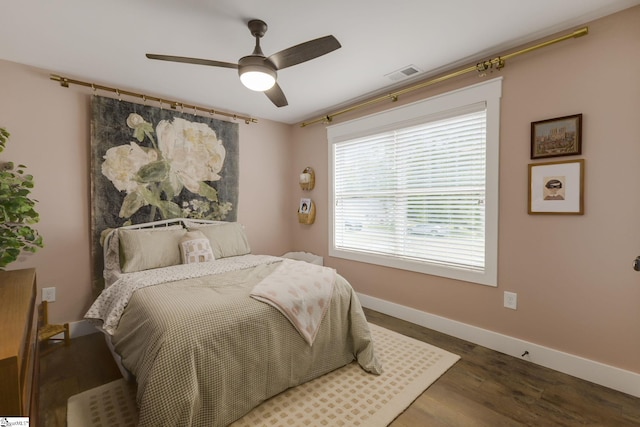bedroom featuring wood finished floors, baseboards, and a ceiling fan