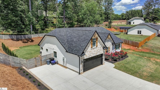 view of front facade featuring stone siding, an attached garage, and concrete driveway