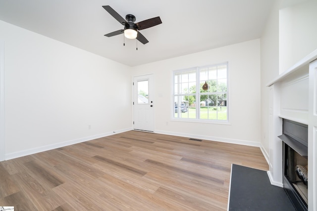 751 Running Creek Ln, Boiling Springs, SC 29316 - unfurnished living room featuring a fireplace with flush hearth, ceiling fan, light wood finished floors, and baseboards