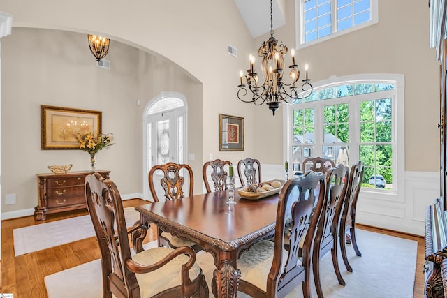 111 Tinsley Ct, Greenville, SC 29615 - dining area featuring arched walkways, wood finished floors, a chandelier, a high ceiling, and healthy amount of natural light