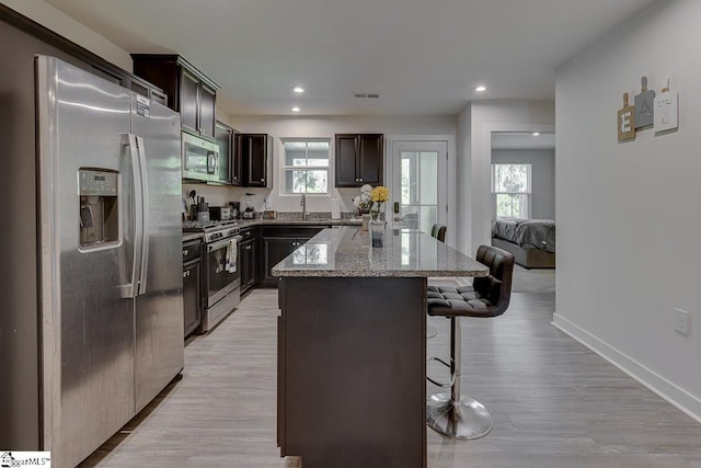 321 Aldworth Ln, Fountain Inn, SC 29644 - kitchen featuring appliances with stainless steel finishes, a breakfast bar area, a sink, a kitchen island, and light stone countertops