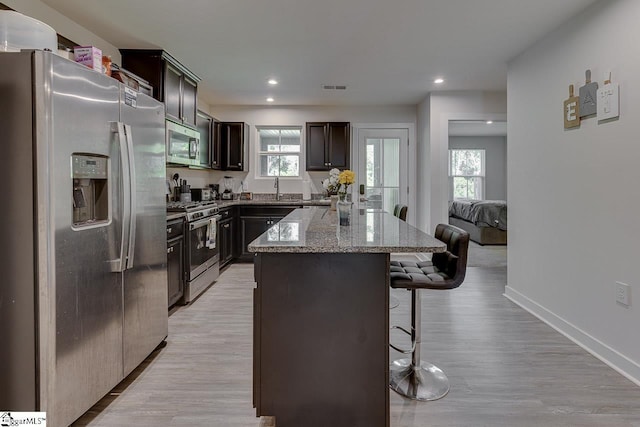321 Aldworth Ln, Fountain Inn, SC 29644 - kitchen with appliances with stainless steel finishes, a sink, a breakfast bar area, a center island, and light stone counters