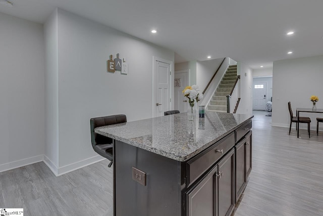 321 Aldworth Ln, Fountain Inn, SC 29644 - kitchen featuring light wood-style flooring, baseboards, light stone countertops, recessed lighting, and a kitchen island