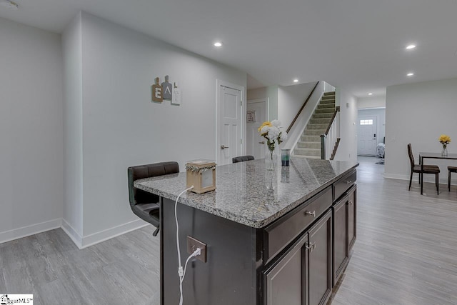 321 Aldworth Ln, Fountain Inn, SC 29644 - kitchen featuring light wood finished floors, baseboards, light stone counters, recessed lighting, and a kitchen island