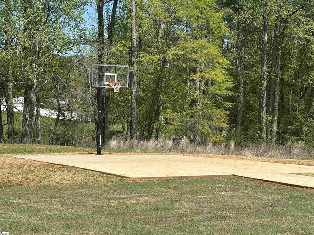 view of basketball court with a lawn and community basketball court