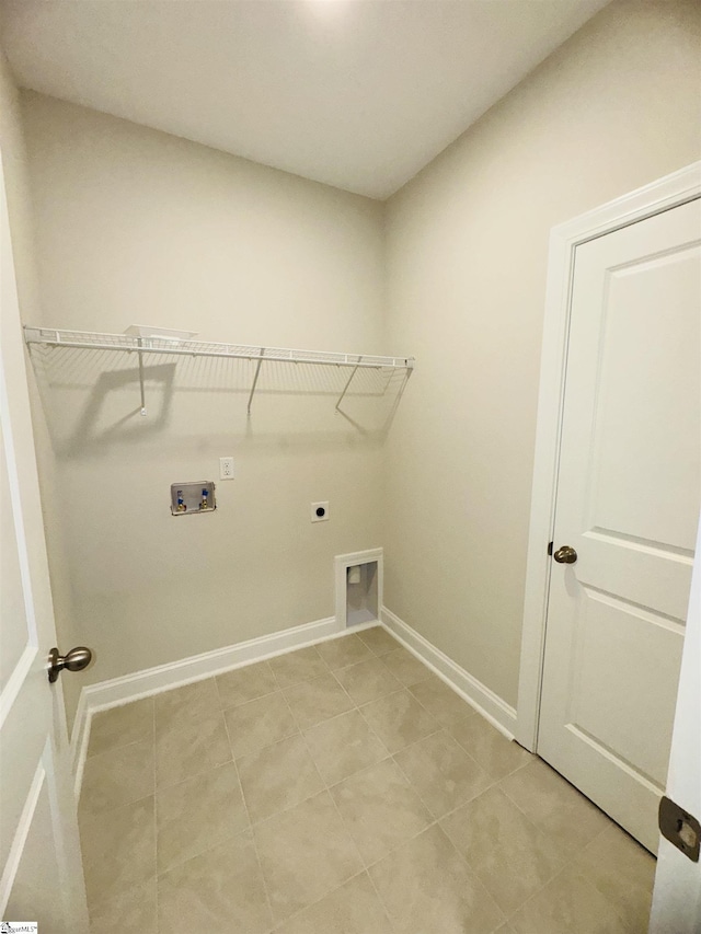 laundry area featuring hookup for an electric dryer, hookup for a washing machine, baseboards, and light tile patterned floors