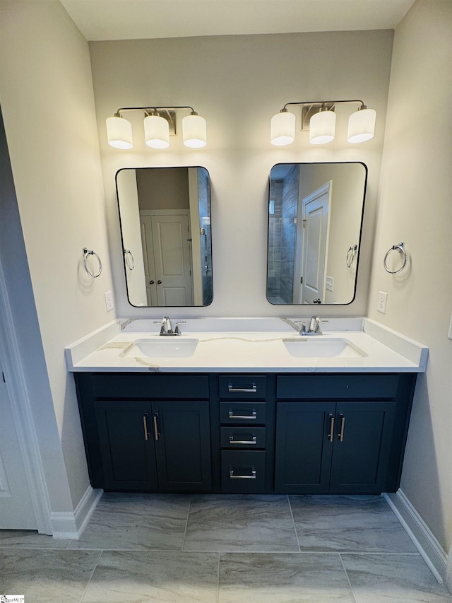 full bath featuring baseboards and double vanity