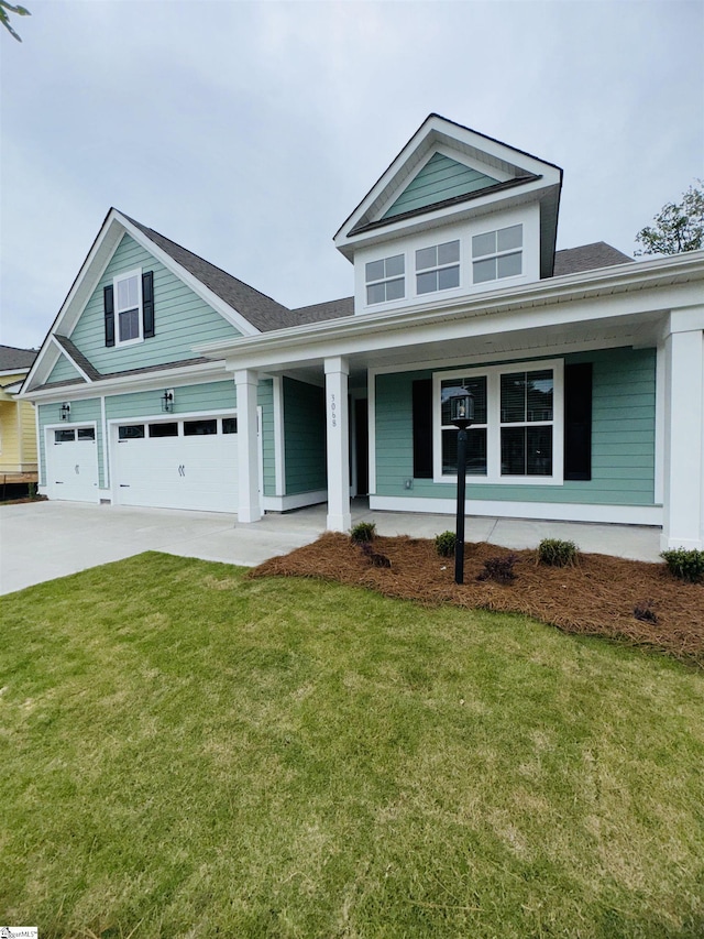 view of front of property with concrete driveway, a porch, and a front lawn
