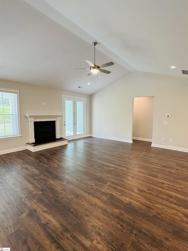 unfurnished living room with dark wood-type flooring, healthy amount of natural light, ceiling fan, baseboards, and lofted ceiling