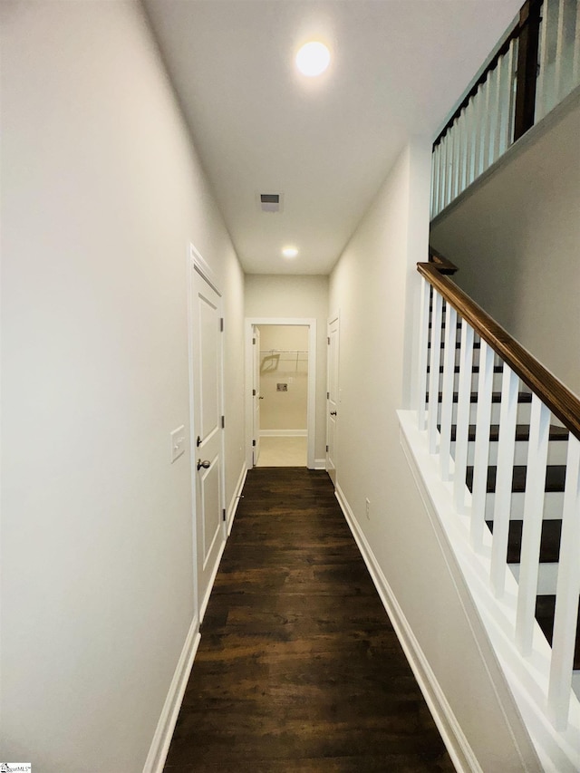 corridor with wood finished floors, baseboards, and stairs