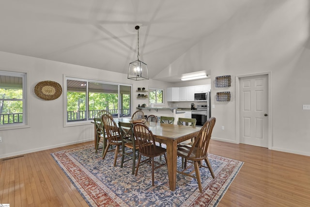 451 Cedar Creek Rd, Sunset, SC 29685 - dining area with light wood-style flooring, baseboards, high vaulted ceiling, and a chandelier