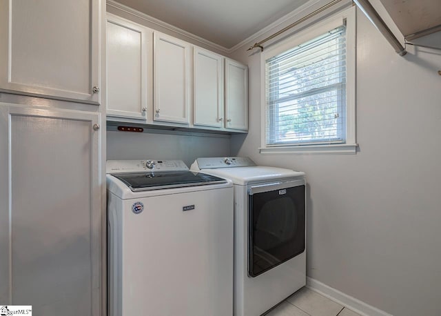 clothes washing area with cabinet space, washing machine and clothes dryer, light tile patterned flooring, baseboards, and crown molding