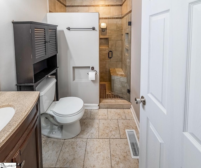 bathroom with a stall shower, baseboards, vanity, and toilet