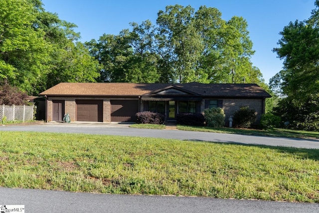 view of front of home with an attached garage, asphalt driveway, and brick siding