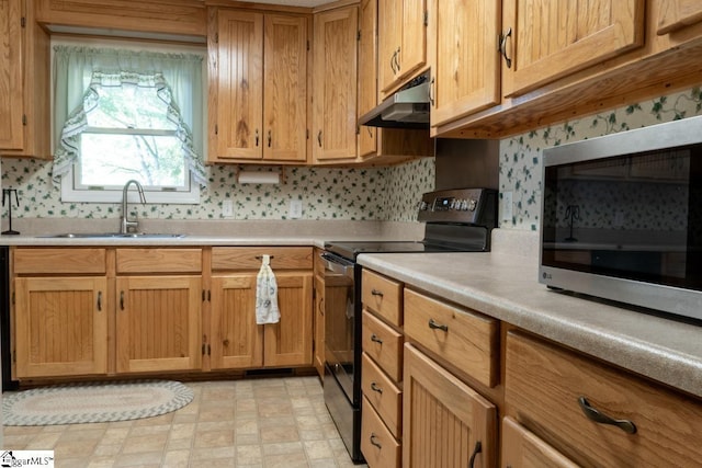 kitchen with black electric range oven, stainless steel microwave, a sink, under cabinet range hood, and light countertops