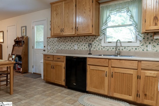 kitchen featuring black dishwasher, a sink, light countertops, and light brown cabinets