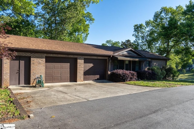 ranch-style house featuring brick siding, an attached garage, and driveway
